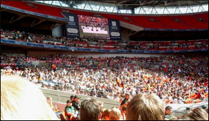 The crowd watch the LYs on Wembley's big screen